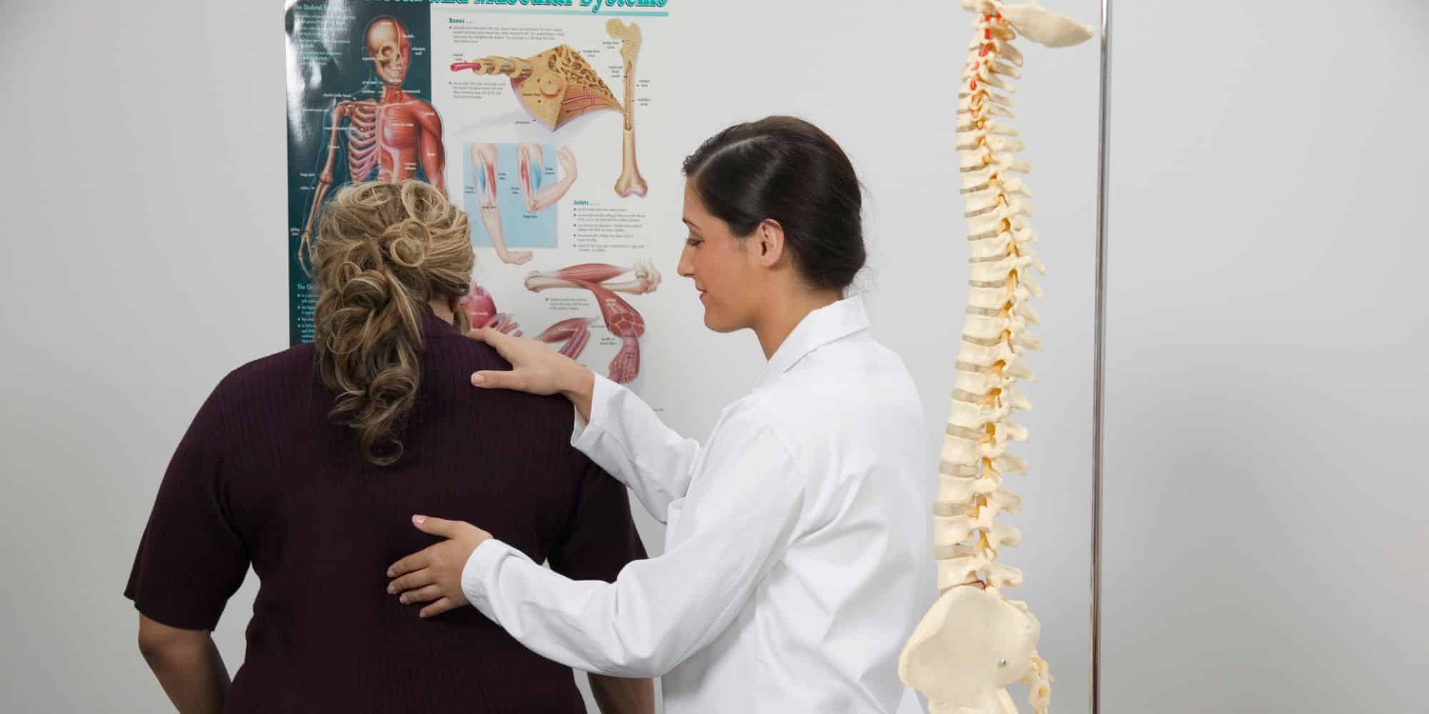 a chiropractor touching a patients back